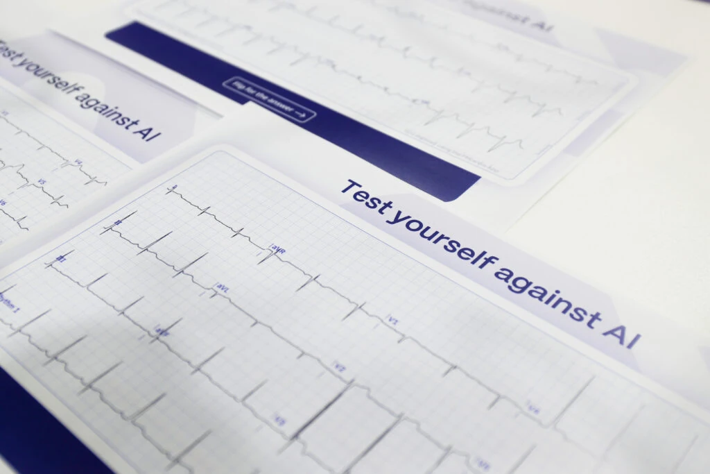 Printed Test yourself against AI 12-lead ECG challenge handouts at the PMcardio ACC.24 booth