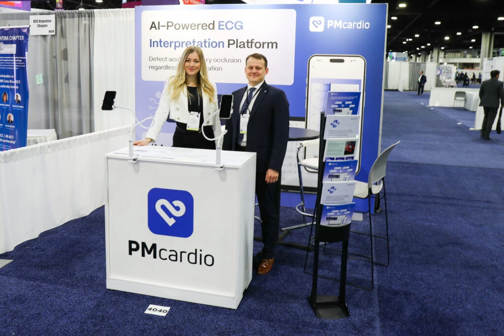 Two Powerful Medical staff holding smartphones at the PMcardio booth 4040 at ACC.24 in Atlanta