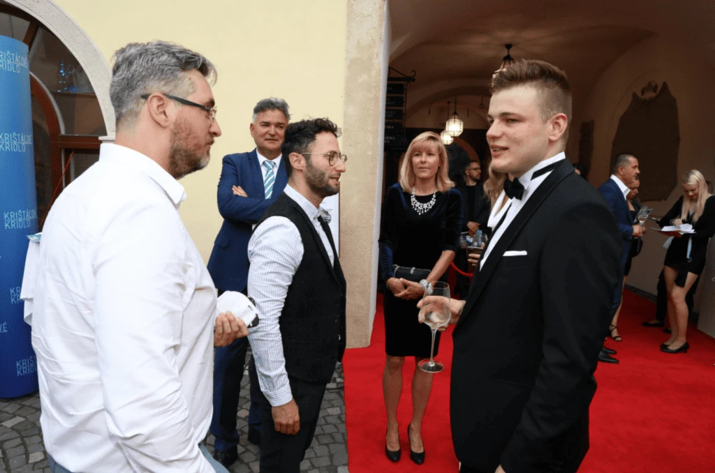 Martin Herman in a tuxedo talking with guests on the red carpet at the Crystal Wing gala