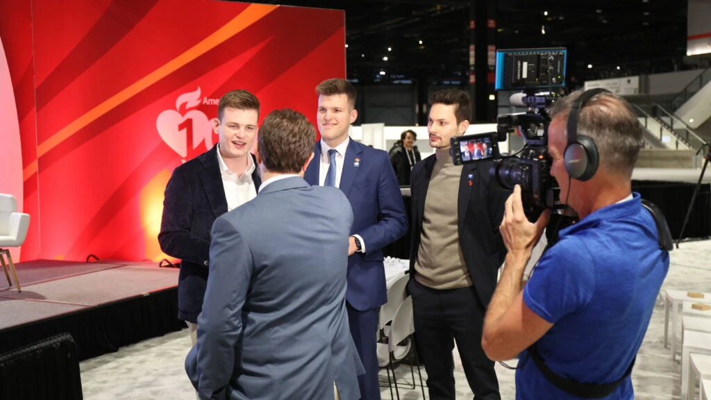 Powerful Medical co-founders interviewed on camera at the AHA 2024 red backdrop in Chicago
