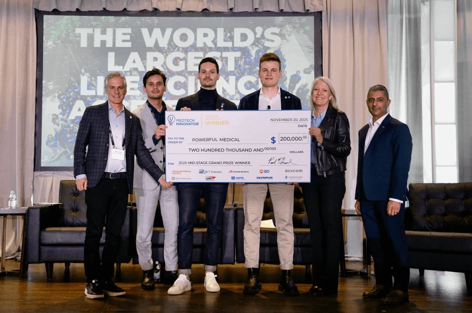 Powerful Medical team on stage holding oversized MedTech Innovator 2025 Winner check for the Mid-Stage Grand Prize