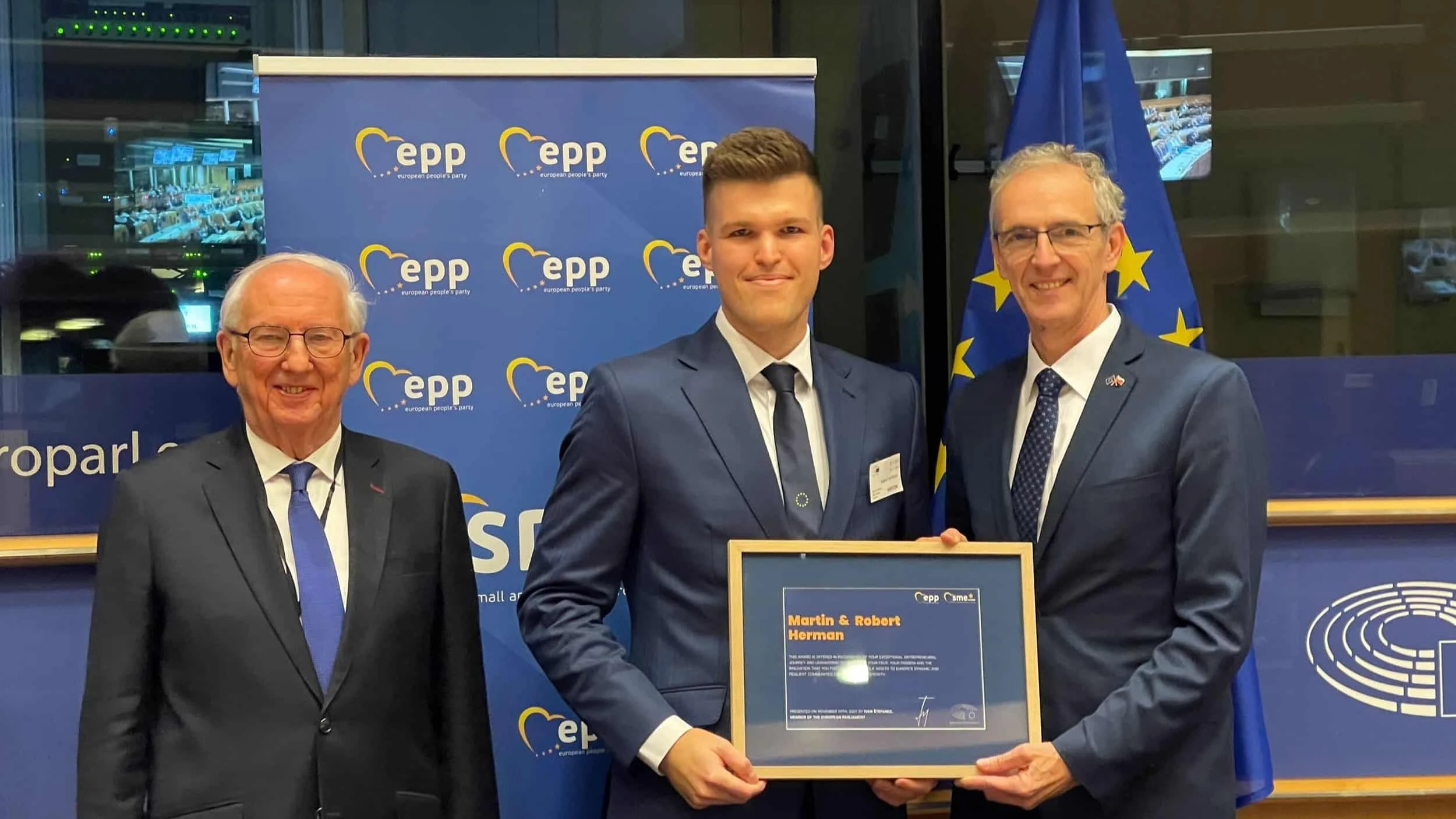 Robert Herman accepting the SME Europe Award beside two officials at the European Parliament, Brussels 2023