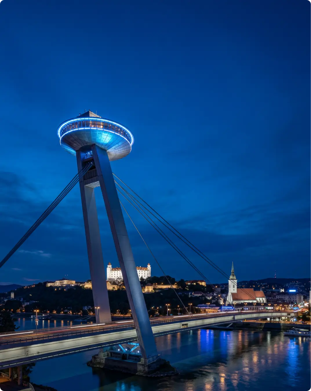 Bratislava at dusk with the UFO bridge and castle over the Danube, Powerful Medical EU office city